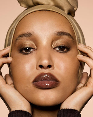 medium skin tone model wearing Gloss Bomb Heat Universal Lip Luminizer + Plumper in shade Hot Chocolit Heat
